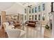 Spacious living room with high ceilings, tall windows, hardwood floors, and leather furniture at 3456 Glen Mist Pl, Dacula, GA 30019