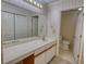 Bathroom with a long white vanity, a large mirror, floral wallpaper, and a toilet room at 107 Ridley Howard Ct, Decatur, GA 30030