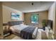 A staged bedroom with a large window view of nature, a gray bedframe, and neutral walls at 107 Ridley Howard Ct, Decatur, GA 30030