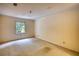 Empty bedroom with carpet flooring, yellow walls, and a window with a wooded view at 107 Ridley Howard Ct, Decatur, GA 30030