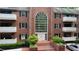 Brick condo building with large arched window, manicured landscaping, and covered balconies provides inviting curb appeal at 107 Ridley Howard Ct, Decatur, GA 30030