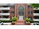 Brick condo building with large arched window, manicured landscaping, and covered balconies provides inviting curb appeal at 107 Ridley Howard Ct, Decatur, GA 30030