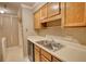 A close-up view of a kitchen sink and counter, showing wood cabinets and peeling wallpaper at 107 Ridley Howard Ct, Decatur, GA 30030