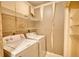 A dated laundry room with a washer, dryer, wire shelves, and peeling wallpaper at 107 Ridley Howard Ct, Decatur, GA 30030