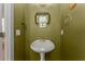 Stylish powder room with pedestal sink, decorative mirror, and elegant fixtures at 1560 Gilstrap Nw Ln, Atlanta, GA 30318