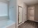 Well-lit bathroom featuring a tub, glass shower, and wood-look flooring at 2089 Lanier Harbor Pt # 2089, Buford, GA 30518