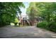 View of the back exterior featuring a parking area and lush, mature landscaping at 338 Candler Rd, Atlanta, GA 30317