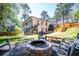Spacious backyard with a stone firepit, patio seating, and steps leading up to the house at 1105 Gun Club Nw Rd, Atlanta, GA 30318