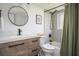 Updated bathroom featuring a modern vanity, round mirror, and tiled shower-tub combo with a neutral color palette at 1105 Gun Club Nw Rd, Atlanta, GA 30318
