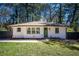 Classic white brick home with a well-manicured lawn, and a freshly painted green front door at 1105 Gun Club Nw Rd, Atlanta, GA 30318
