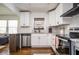 Bright kitchen with stainless steel appliances, granite countertops, white cabinets, and hardwood floors at 1105 Gun Club Nw Rd, Atlanta, GA 30318