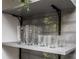 Open shelving displaying glasses complement backsplash and black support brackets at 1105 Gun Club Nw Rd, Atlanta, GA 30318
