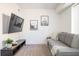 Modern living room with gray sofa, mounted TV, and carpet flooring at 1105 Gun Club Nw Rd, Atlanta, GA 30318