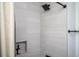 This shower is tiled with black fixtures and a shelf for storage, with a neutral toned shower curtain at 1105 Gun Club Nw Rd, Atlanta, GA 30318