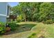 Large backyard featuring lush green grass, mature trees, and a charming footbridge at 1810 Annie Nw St, Atlanta, GA 30318