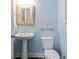 Charming half bathroom features pedestal sink, framed mirror, and soft blue walls at 1810 Annie Nw St, Atlanta, GA 30318