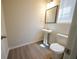 Bathroom features pedestal sink, toilet, and neutral paint with wood-look flooring at 458 Bishop Ln, Woodstock, GA 30188