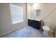 This bathroom features a dark vanity, gray tile flooring, and a window with bright natural light at 458 Bishop Ln, Woodstock, GA 30188
