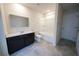 Bright bathroom with a combination tub and shower, dark vanity and gray tile floors at 458 Bishop Ln, Woodstock, GA 30188