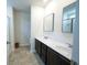 Bright bathroom with double sinks, dark wood cabinets, large mirrors, tile floors, and a glass-enclosed shower at 458 Bishop Ln, Woodstock, GA 30188