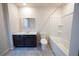 Bright bathroom with a combination tub and shower, dark vanity and gray tile floors at 458 Bishop Ln, Woodstock, GA 30188