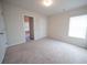 A spacious bedroom featuring neutral walls, plush carpeting, and a window with blinds at 458 Bishop Ln, Woodstock, GA 30188