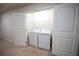 A clean laundry room featuring a white washer and dryer set and a wire rack shelf above at 458 Bishop Ln, Woodstock, GA 30188