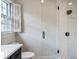 Modern bathroom featuring glass shower, white subway tile, and toilet with white shuttered window at 609 Pinetree Dr, Decatur, GA 30030