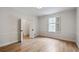 Sunlit bedroom with hardwood floors, white walls, and large window at 609 Pinetree Dr, Decatur, GA 30030