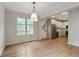 Bright dining area open to a kitchen featuring hardwood floors, white cabinets, and stainless steel appliances at 609 Pinetree Dr, Decatur, GA 30030