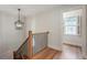 Hallway showcasing hardwood floors, black metal railings, and a window providing natural light at 609 Pinetree Dr, Decatur, GA 30030
