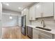 Well-lit kitchen with stainless steel appliances, white cabinets, and dining area access at 609 Pinetree Dr, Decatur, GA 30030