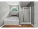 Bright bathroom featuring a bathtub with jets, separate shower, and wood-look floors at 2086 Grant Ave, Mcdonough, GA 30252