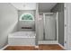 Bright bathroom featuring a soaking tub under an arched window and glass shower at 2086 Grant Ave, Mcdonough, GA 30252