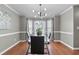 Elegant dining room with hardwood floors, modern chandelier, and a glass table set in a light-filled space at 2086 Grant Ave, Mcdonough, GA 30252