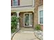 Close-up of the front door with decorative glass and brick surround, framed by a pathway and manicured landscaping at 2086 Grant Ave, Mcdonough, GA 30252