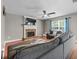 Bright living room with a brick fireplace, tv, ceiling fan, and hardwood floors, ideal for entertaining at 2086 Grant Ave, Mcdonough, GA 30252