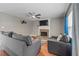 Comfortable living room featuring a brick fireplace with a TV and hardwood floors at 2086 Grant Ave, Mcdonough, GA 30252