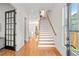 Inviting entryway featuring hardwood floors, staircase, and access to the kitchen at 437 E Ontario Sw Ave, Atlanta, GA 30310