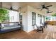 Relaxing covered porch with a swing bed, chairs, and multiple ceiling fans at 437 E Ontario Sw Ave, Atlanta, GA 30310