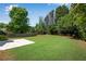 This large backyard features a grassy area with trees and a stone patio at 4769 Ellington Ct, Marietta, GA 30067