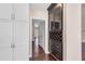 Hallway with white trim, hardwood floors, white cabinets, and a dark wood hutch with wine storage at 4769 Ellington Ct, Marietta, GA 30067