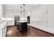 White kitchen with stainless steel appliances, a dark island with white countertop, and hardwood floors at 4769 Ellington Ct, Marietta, GA 30067