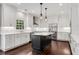 A modern kitchen features white cabinets, stainless steel appliances, and a dark island with a white countertop at 4769 Ellington Ct, Marietta, GA 30067