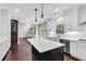 Open concept kitchen with white cabinets, a dark island, stainless steel appliances, and hardwood flooring at 4769 Ellington Ct, Marietta, GA 30067