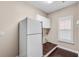 Laundry room featuring a white refrigerator, wood floors, and white window blinds and cabinets at 4769 Ellington Ct, Marietta, GA 30067