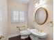 Powder room with a sink, toilet, wood floors, and wallpaper that creates a cozy space at 4769 Ellington Ct, Marietta, GA 30067