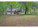 Large backyard with lush greenery, mature trees, and spacious deck at 5295 Old Trail Cir, Stone Mountain, GA 30088