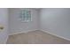 A simple bedroom with neutral-colored walls, carpet, and a window with blinds at 5295 Old Trail Cir, Stone Mountain, GA 30088