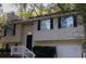 Attractive split-level home featuring neutral siding, black shutters, and a one-car garage at 5295 Old Trail Cir, Stone Mountain, GA 30088